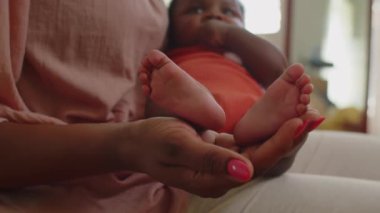 Afrika kökenli Amerikalı yeni doğmuş bebeğin ayakları annesinin ellerinde.