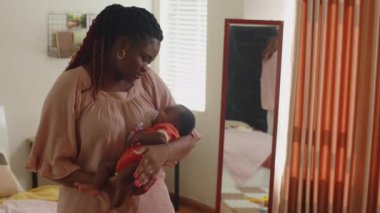 Sevgi dolu bir anne, yeni doğmuş tatlı kızını evinde sakinleştiriyor.