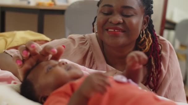 年轻的爱黑人的母亲在家里用橙色的篮子和女婴玩耍的缺乏重点 — 图库视频影像