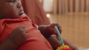 Güzel Afro-Amerikalı bir kızın çıngıraklı elleriyle annesinin ellerine oturduğu portreyi kaldır.