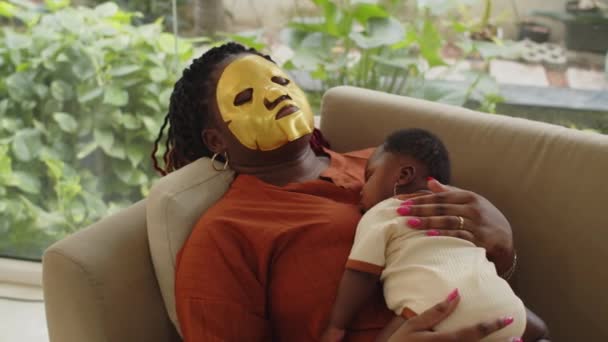 Pan Shot Black Mother Hydrating Mask Face Taking Nap Baby — ストック動画