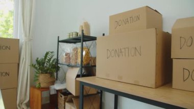 Gönüllü merkezindeki depoda karton kutular ve ihtiyacı olan insanlar için yiyecek var.