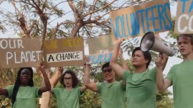 Çevre kirliliğini protesto eden ve gezegenimizi pankartlarla kurtarmak isteyen beş farklı zoomerın düşük açılı görüntüsü.