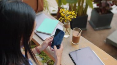Kafe web sitesi için akıllı telefondan kahve ve çiçek çeken siyah saçlı kadın UX tasarımcısının arka planı