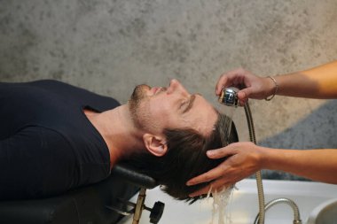 Şampuan sürmeden önce müşterinin saçını durulamak.