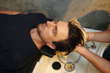 Adamın saçı berber dükkanında yıkanmış.