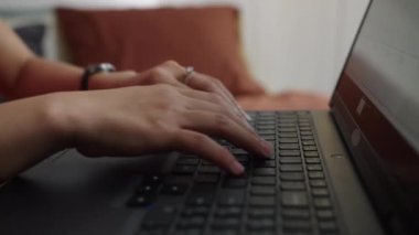 Evden çalışırken kablosuz dizüstü bilgisayarın klavyesine yazarken tanınmayan birinin el görüntüsü.