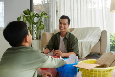Vietnamlı baba ve oğul birlikte vakit geçirip geri dönüşüm ve atık ayıklamayı öğreniyorlar.