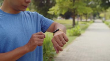 Sporcunun sabah parkta spor yaparken nabzını ve hareketlerini kontrol etmek için akıllı viraj kullanırken görüntüsü kesilmiş.