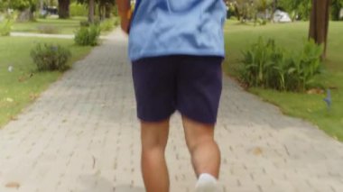 Maraton koşarken parkta koşan erkek sporcunun görüntüsü.