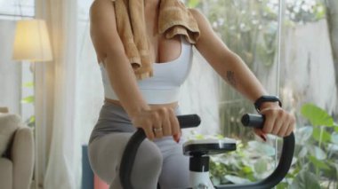 İspanyol sporcu kızın portresini kaldır spor bisikletinin üzerinde otur ve kameraya gülümse.