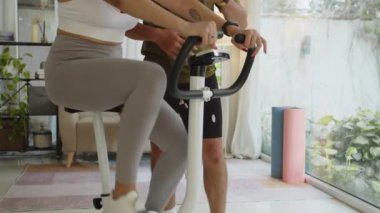Genç İspanyol sporcunun, antrenman sırasında Asya koçu ile bisiklet sürerken çekimini kaldır.