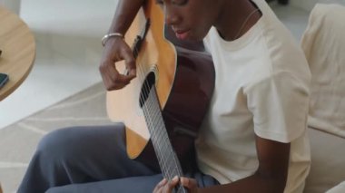 Genç Afrikalı Amerikalı kadının evde gitar çalışmasını çek.