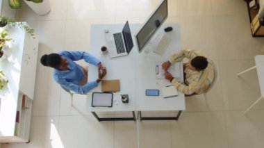 Ofis masasında otururken iki farklı çalışanın el sıkışmasını izle