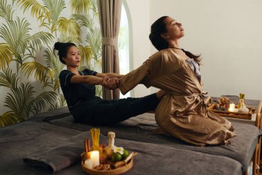 Masöz, göğsünü açmak için müşteriye silah çekiyor.