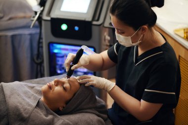 Kadın güzellik kliniğinde mikro estetik ameliyatı oluyor.