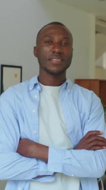 Ofiste çalışırken kameraya gülümseyen Afrikalı Amerikalı neşeli erkek CEO portresi.