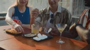 Kafede kokteyl içerken üç kişinin abur cubur yediği sahneler.
