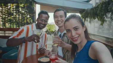 Barda buluşurken selfie için poz veren üç neşeli çift ırklı arkadaşın POV 'u