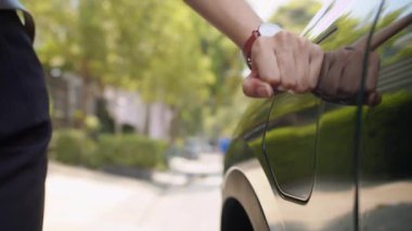 Tanımlanamayan kadın sürücünün dış istasyondan EV araba aküsünü şarj etmek için şarj prizi takması, sürdürülebilir enerji kavramı.