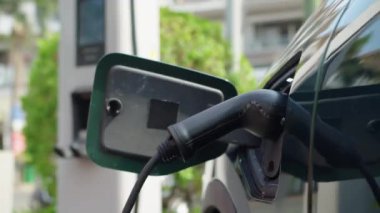 Şehirdeki şarj istasyonunda elektrik kablosu takılı, açık şarj portunda vurulan kimse yok.