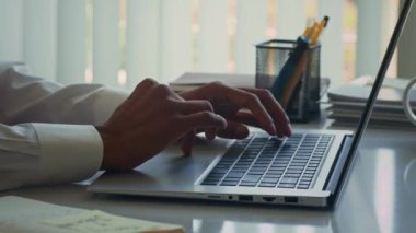 Girişteki masada otururken kablosuz bilgisayarda yazan tanınamayan erkek solofenatörün el kesimi.