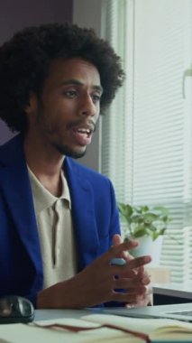 Ofisteki video görüşmesi sırasında Afrikalı Amerikalı bir erkeğin dikey görüntüsü.