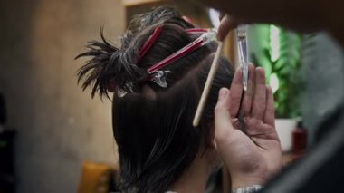 Saç atölyesinde erkek kuaförünün saç tarama ve budama sahnesi.