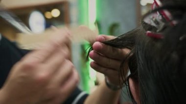 Berber dükkanında adamın saçını tarayan ve kesen tanınmamış bir berberin elleri.