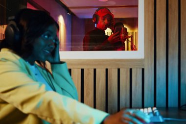 Stüdyoda müzik yapımcısıyla şarkı söylerken