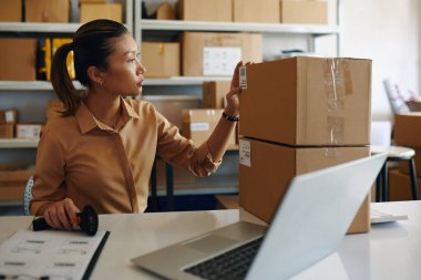 Genç bir kadın teslimattan önce barkodları kontrol ediyor.