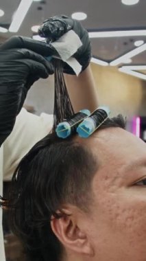 Modayı takip eden kuaförde tanınmayan berber saçlarının dikey çekimi.