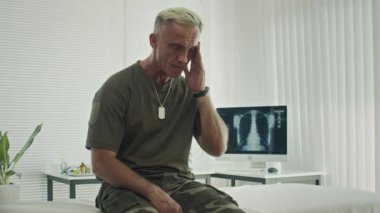 Kafkasyalı askerin klinik koğuşunda otururken teşhisini düşünürken orta boy fotoğrafı.