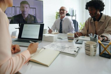 Müşterilerle çevrimiçi toplantı sırasında yeni iş stratejisi üzerinde çalışan bir grup pazarlamacı