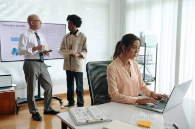 Bir grup iş arkadaşı, pazarlama departmanındaki çalışmaları sırasında birlikte iş birliği yapıyor ve yeni projeleri tartışıyorlar.