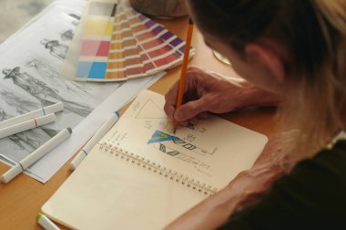 Yeni koleksiyonunu geliştirmek için çizim albümündeki tasarım modelinin yüksek açılı görüntüsü