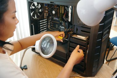 Master atölyedeki bilgisayar detaylarını vidalamak için tornavida kullanıyor