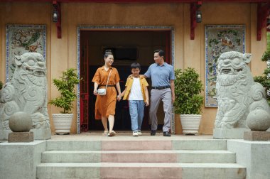 Ebeveynler oğluyla birlikte tapınağı ziyaret ediyor.