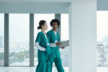 Üniformalı meslektaşlar hastane koridorunda yürürken teşhisi tartışıyorlar.