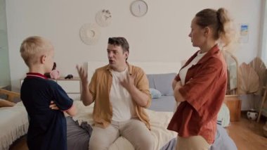 Beyaz bir adamın, evdeki aile kavgası sırasında karısıyla oğlu arasında arabuluculuk yaptığı orta boy bir fotoğraf.