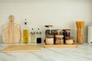 Mutfak masasında mısır gevreği ve soslar var. Yemek pişirmeye hazırlanıyorlar.