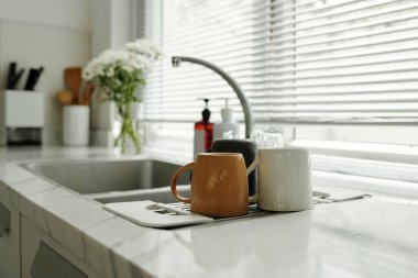 Ev mutfağında temiz bardaklarla lavabo.