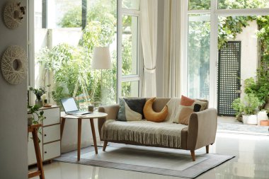 Panoramik pencereleri ve kanepesi olan büyük bir tasarım salonu.