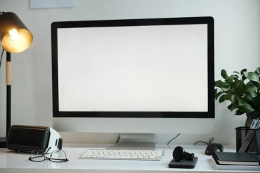 Büyük monitörlü ve diğer cihazlı işyeri.