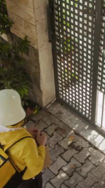 Erkek kuryenin kadın müşteri toplantısına çantasıyla ev kapısında dikey görünümü