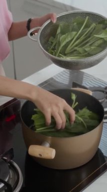 Mutfakta salata pişirirken tanınmayan bir kızın dikey fotoğrafı.