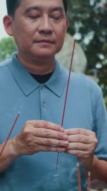 Asya kökenli insan ve ailenin dikey görüntüsü sunak başında antik tapınağı ziyaret ederken ve dua ederken.