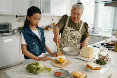 Büyükannem torununa kahvaltı hazırlıyor.
