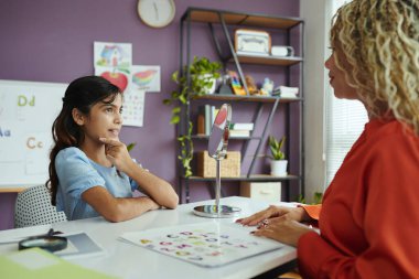 Sınıfta bir öğretmenle alfabe okuma ve telaffuz pratiği yapan bir öğrenci.