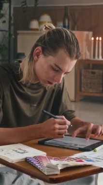 Kafkas etnik kökenli erkek Z moda yaratıcısının stüdyodaki tablet bilgisayardan dikey görüntüsü